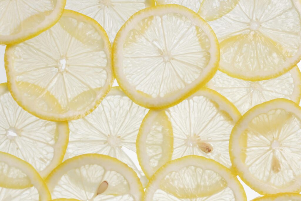 Vibrant close-up of fresh lemon slices arranged on a white surface, showcasing their texture and freshness.