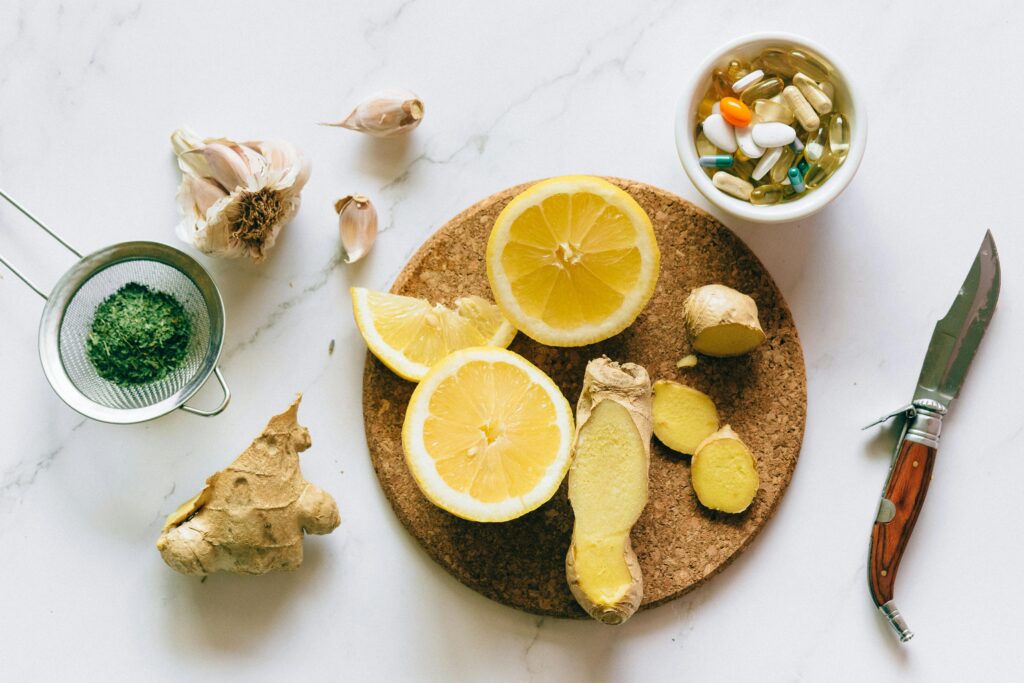 Flat lay of natural remedies including lemon, ginger, and garlic alongside pills.