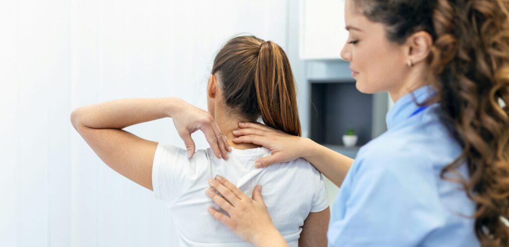 A healthcare professional provides a physical examination to a patient experiencing discomfort in her neck and shoulder area, emphasizing the importance of Friday Health in maintaining well-being.