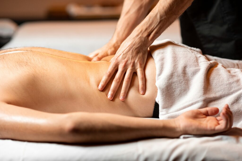 A massage therapy session in a soothing environment, highlighting the hands of a therapist gently applying pressure to the back of a client, promoting relaxation and well-being through Friday Health practices.