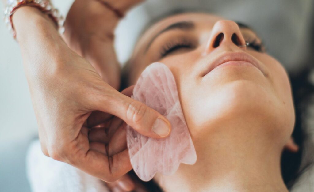 A serene spa experience featuring a woman enjoying a soothing gua sha massage for relaxation and wellness.