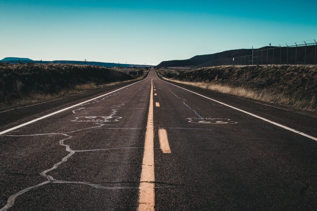 Long stretch of the iconic Route 66 with clear skies and road markings, perfect for travel themes.