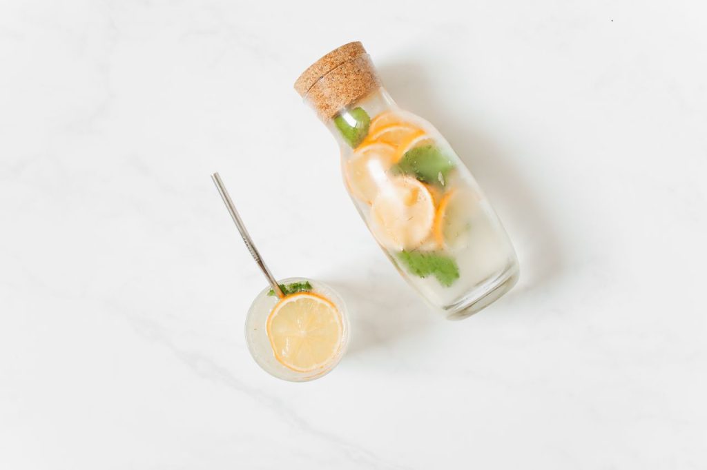 Top view of refreshing citrus mint infused water in glass and jar, perfect for a healthy lifestyle.
